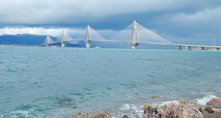 Vue panoramique côtière du pont Rio-Antirrio sous des nuages d'orage dramatiques.