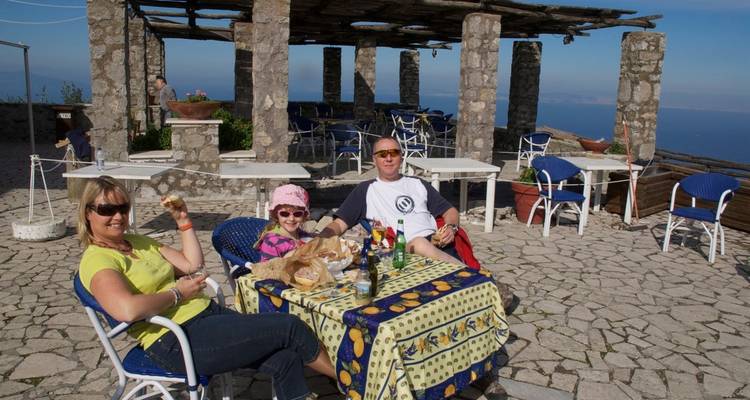 Famille assise et dégustant un repas avec une vue panoramique.
