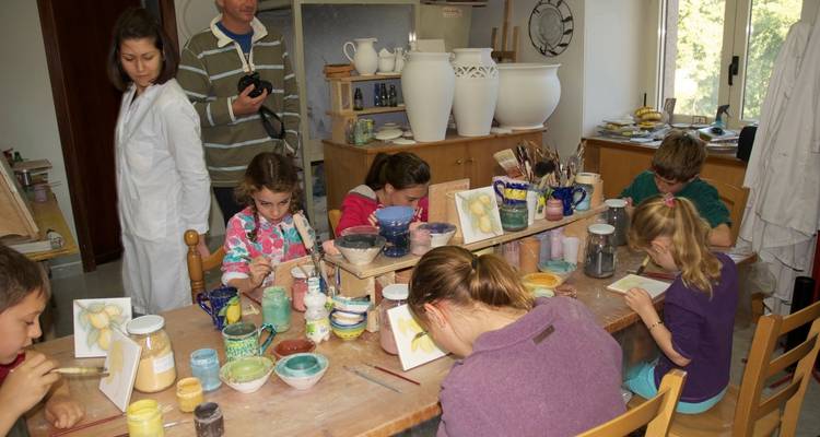 Enfants peignant des poteries dans un atelier.