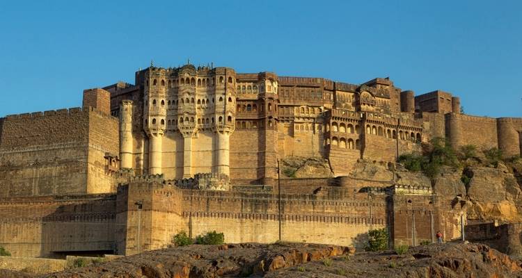 Un fort massif construit en grès rouge, se dressant sur un terrain rocheux.