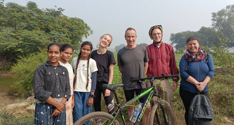Grupo de turistas y lugareños posando juntos en un entorno rural.