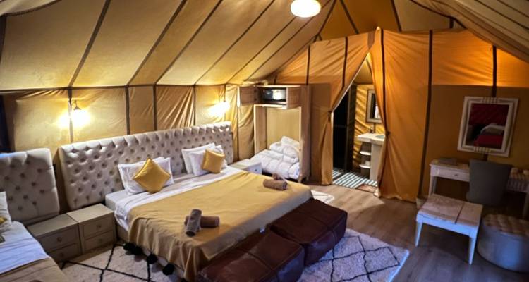 Intérieur d'une tente élégante avec une literie confortable.