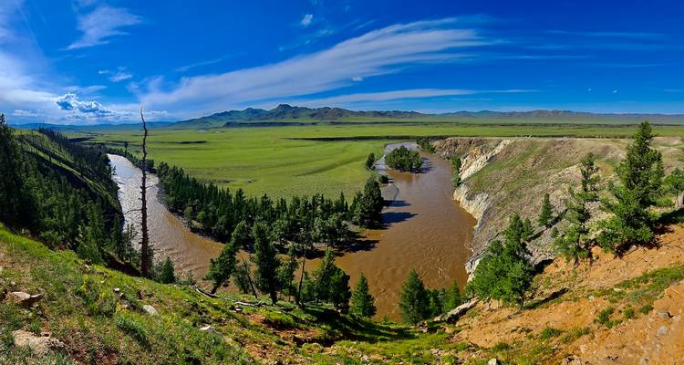 Un río serpenteando a través de un paisaje montañoso verde.