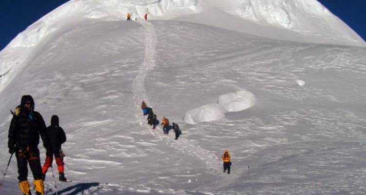 Climbers making their way up a snowy peak.