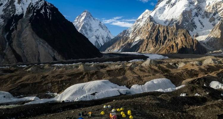 Mountainous landscape with tents and glaciers.
