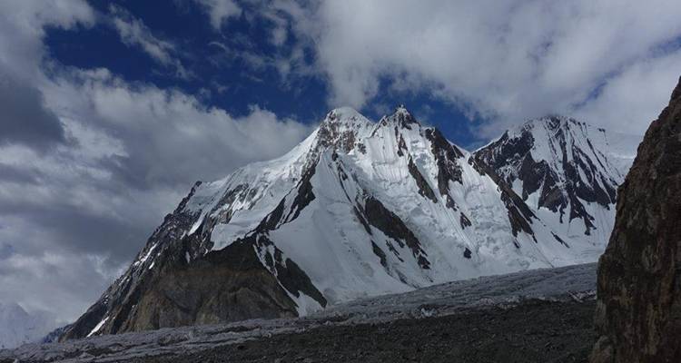Snow-covered peaks under a partly cloudy sky.