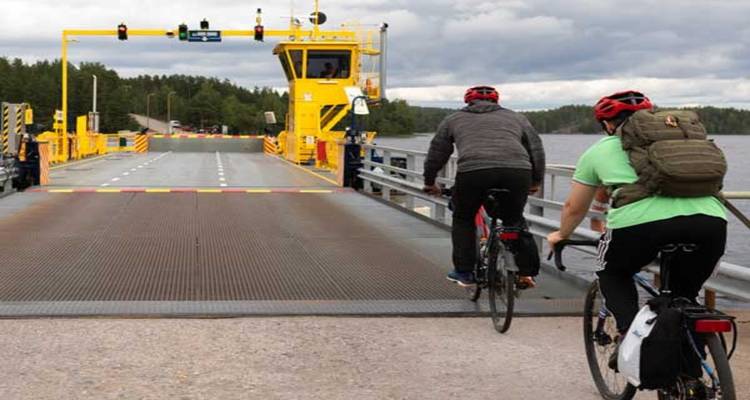 Cyclistes approchant d'un ferry à une traversée de lac.