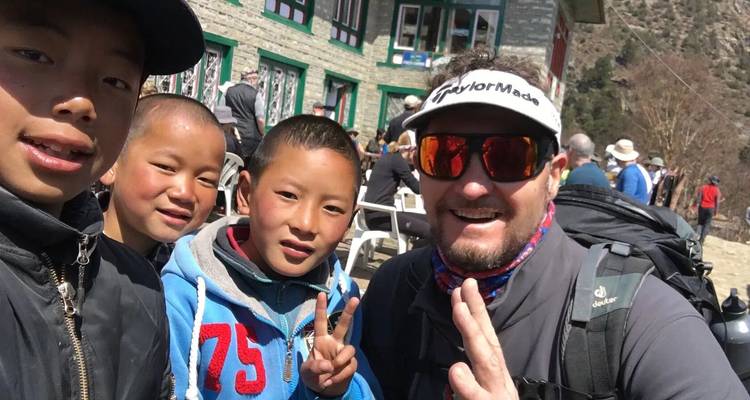 Group selfie with several smiling people in an outdoor setting.