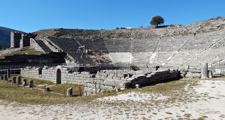 Antiguo teatro de piedra de Dodona con asientos semicirculares y escenario parcialmente restaurado.
