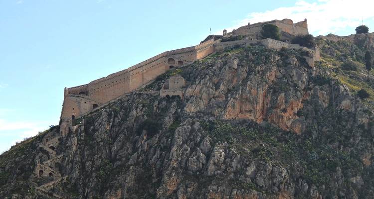 Versterkte muren van het Palamidi-fort die zich uitstrekken over een steile rotsachtige berg.
