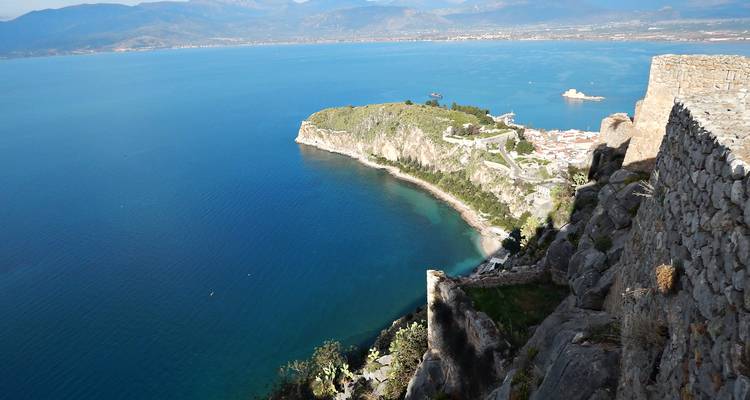 Panoramisch uitzichtpunt over de baai en het schiereiland van Nafplio met turquoise wateren ver beneden.