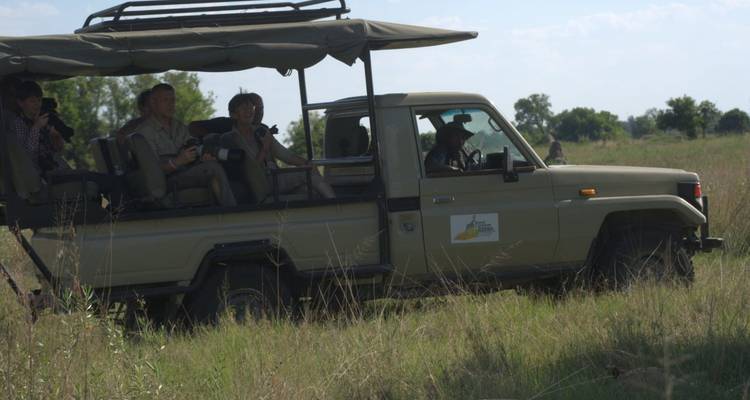 Toeristen in een safarivoertuig die foto's maken.