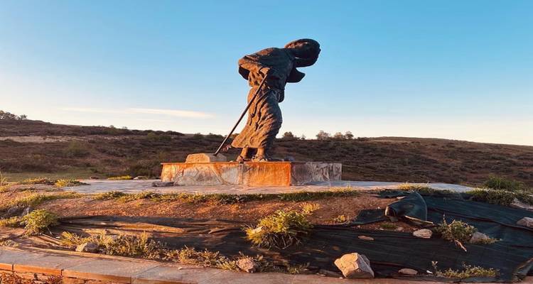 Standbeeld op een heuvelflank tijdens zonsopgang