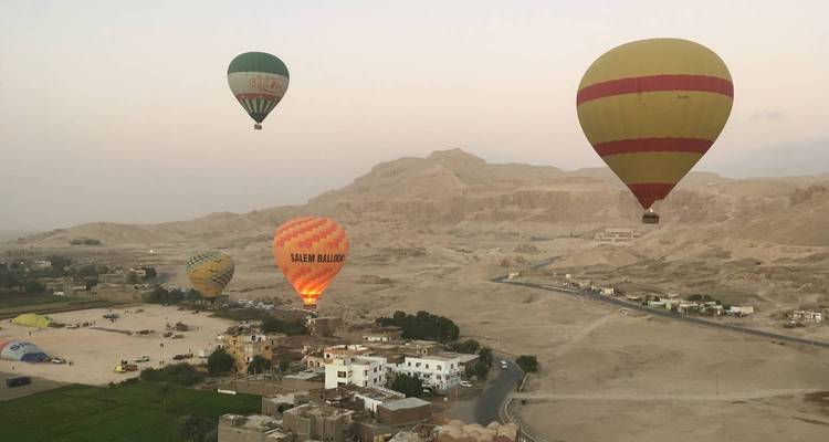 Les ballons à air chaud flottant au-dessus du paysage désertique de Louxor à l'aube