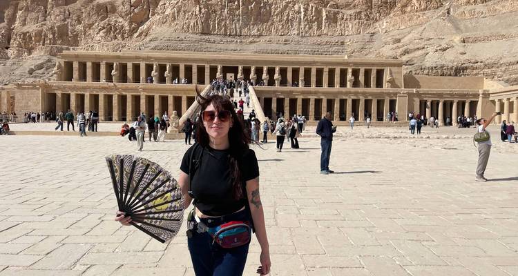 Touriste féminine tenant un éventail devant le Temple en terrasses de Hatshepsut avec des foules à l'arrière-plan