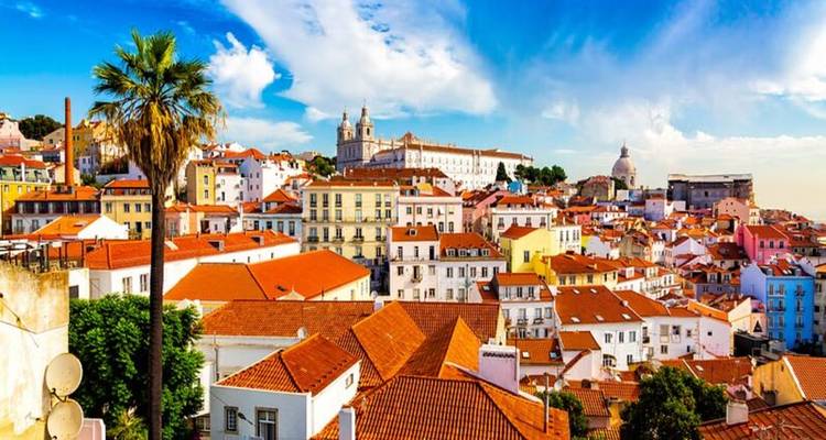 Panoramic view of Lisbon with colorful buildings and a blue sky.