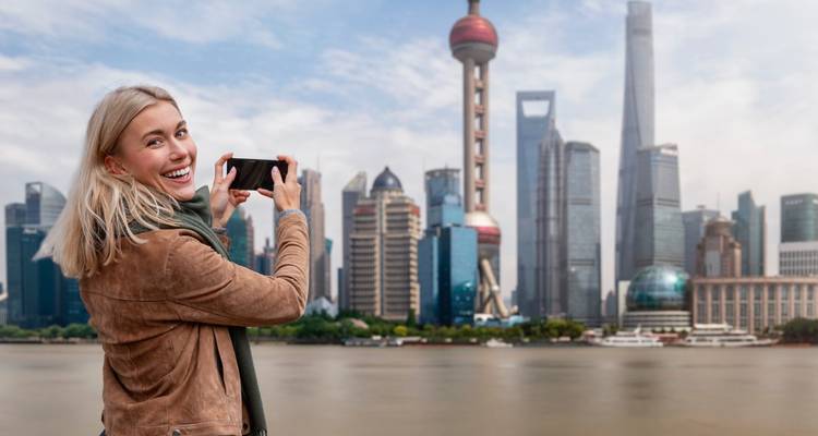 Personne prenant une photo avec la célèbre Tour de la Perle de l'Orient en arrière-plan.