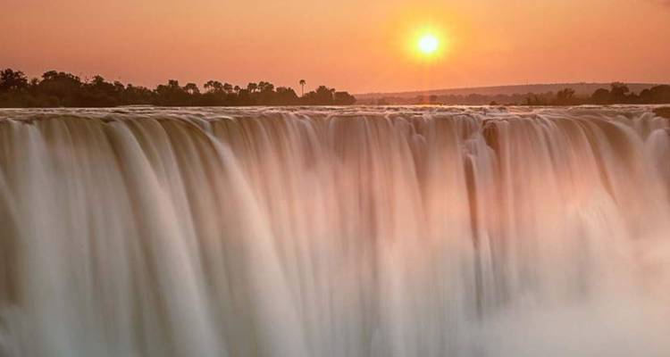 Victoriafälle bei Sonnenuntergang mit Nebel und Wasserfall.