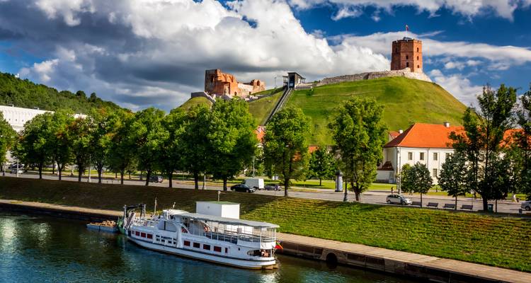 Vista de la Torre de Gediminas en una colina con un río abajo y un barco.