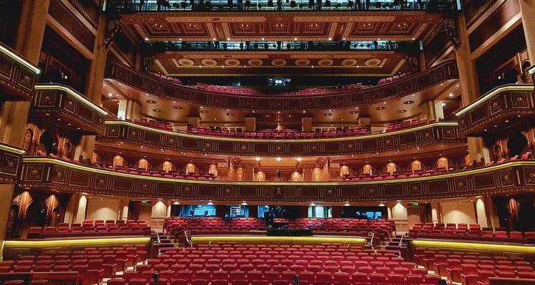 Interior de un teatro ornamentado y vacío con múltiples niveles de asientos.