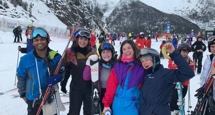 Group of skiers and snowboarders posing on a snowy mountain.