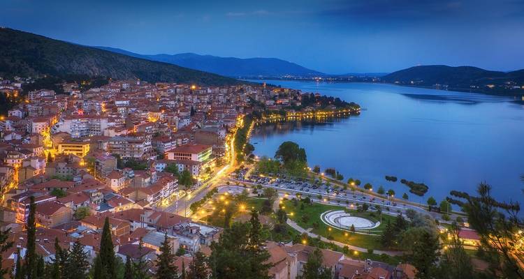 Evening view of a lakeside town with illuminated streets.