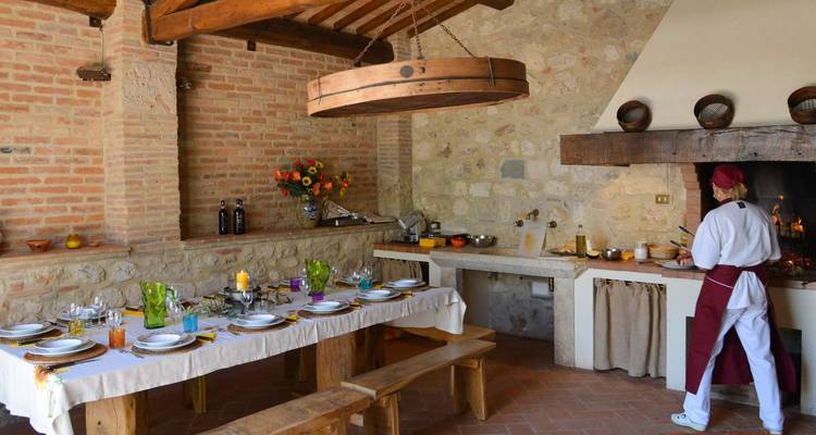 Chef préparant de la nourriture dans un cadre de cuisine rustique.