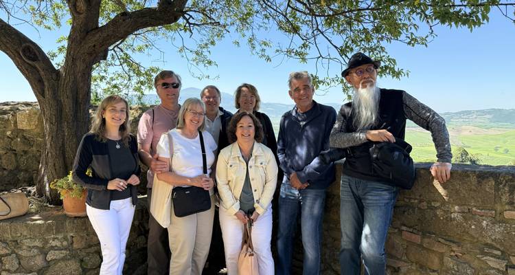 Groupe de personnes posant sous un arbre avec une vue panoramique.