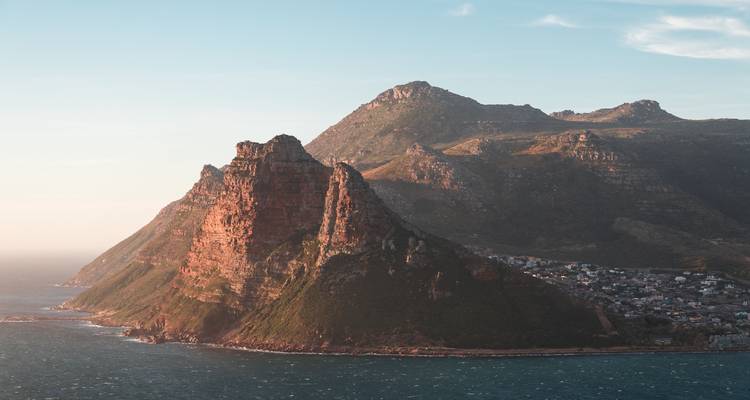 La luz dorada ilumina los escarpados acantilados de Chapman's Peak que se extienden hacia el Océano Atlántico.