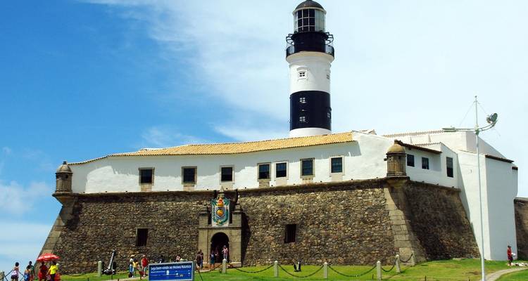 Une forteresse avec un phare sur la côte.