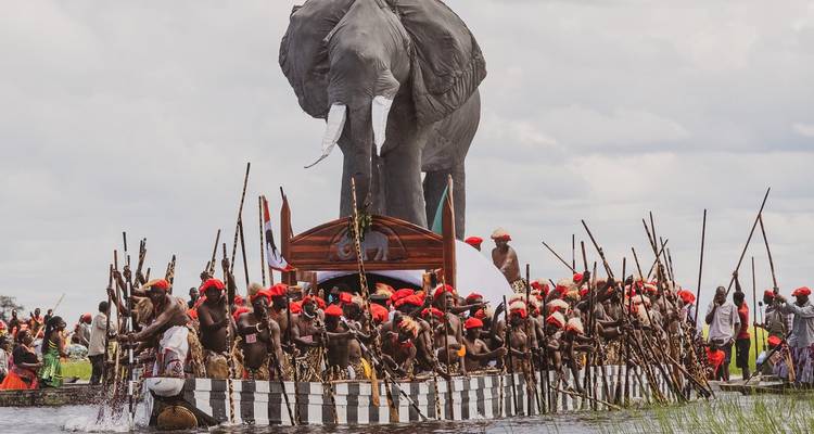 Personnes participant à un événement culturel avec un grand char en forme d'éléphant.