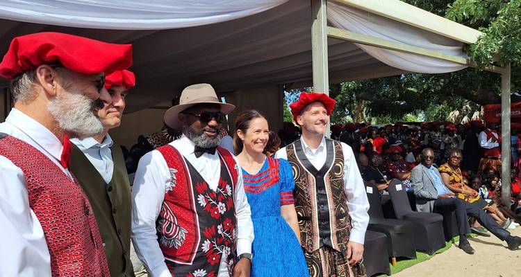 Groupe de personnes en tenue traditionnelle posant pour une photo lors d'un événement.