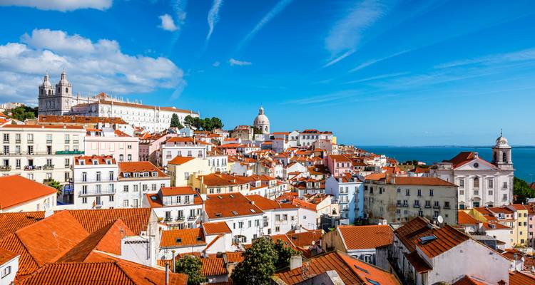 Vue d'une ville côtière avec des toits en terre cuite et une architecture historique au bord de la mer.