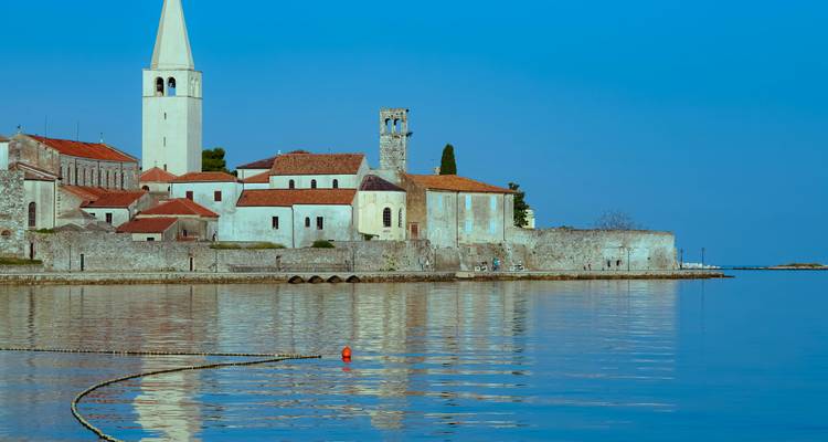 Historische kustplaats met een prominente kerk en kalme wateren.