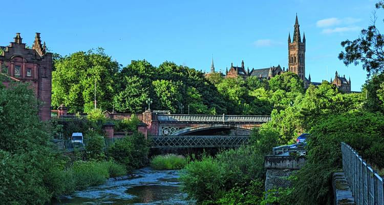 Blick auf eine historische Stadtlandschaft mit einem Fluss und einer Brücke.