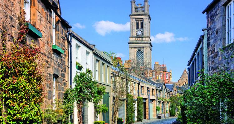 Eine malerische Straße mit historischen Gebäuden und einer Kirche im Hintergrund.