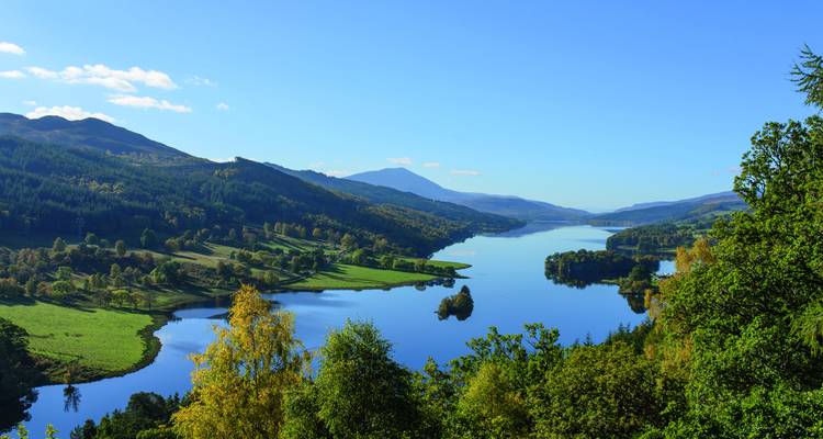Ruhige Flusslandschaft mit Hügeln und Spiegelungen.