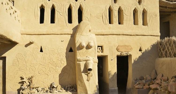 Bâtiment historique en briques de terre cuite avec décorations sculpturales.