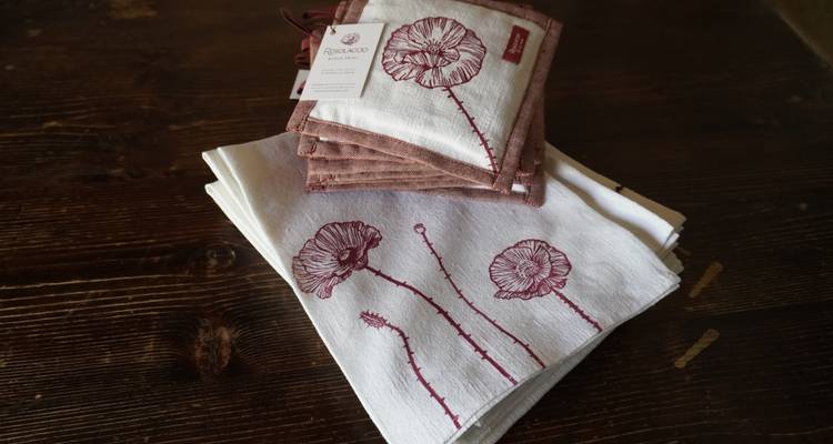 Servilletas de tela hechas a mano con diseños florales sobre una mesa de madera.