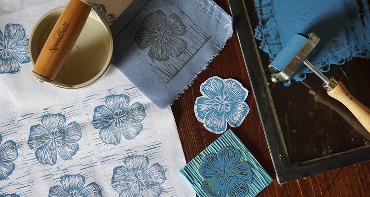 Láminas artísticas y herramientas dispuestas sobre una mesa.