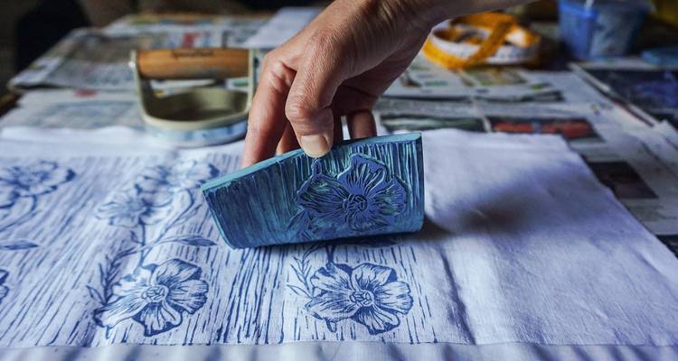Persona usando un sello para crear patrones en tela.