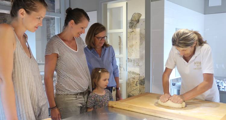 Grupo de personas viendo una demostración culinaria.