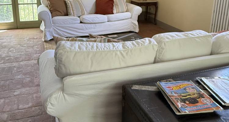 Sala de estar con sofás acolchados y revistas en una mesa de centro.