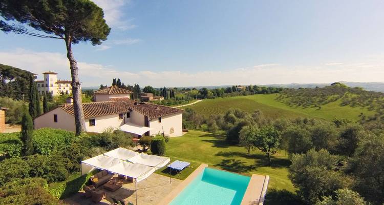Vue d'une villa avec une piscine et le paysage environnant.