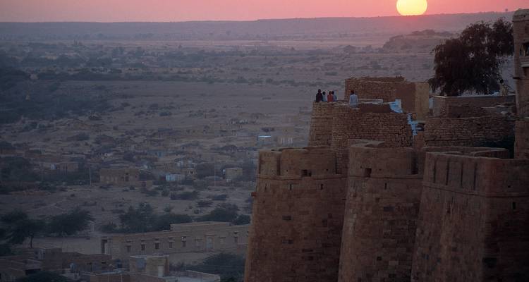 Blick bei Sonnenuntergang über die alten Festungsmauern und die ferne Landschaft.