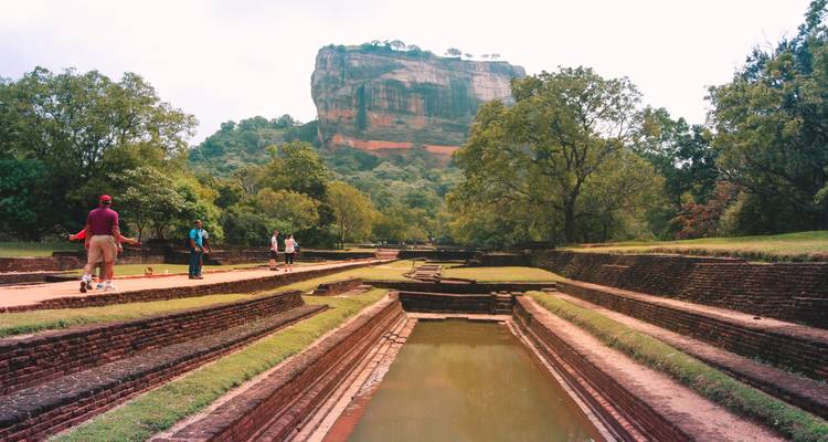 "Fortaleza de la Roca de Sigiriya con turistas alrededor de los jardines."