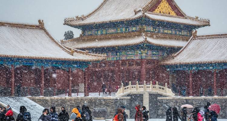 Winterscène van de Verboden Stad met sneeuw en toeristen.