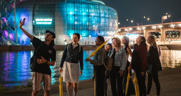 Los viajeros se toman una selfie grupal por la noche junto a la isla flotante iluminada del río Han en Seúl