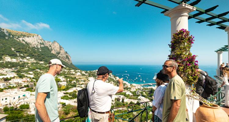 Turistas en una terraza con vista panorámica costera.
