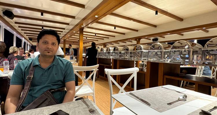 Persona sentada en un área de comedor en un crucero con estaciones de buffet.